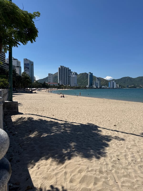 Morning on Nha Trang beach, skyline backdrop, quiet shoreline.