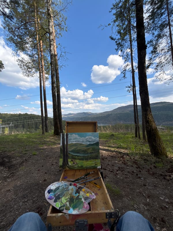 Artist paints Yenisey River landscape outdoors in Krasnoyarsk forest