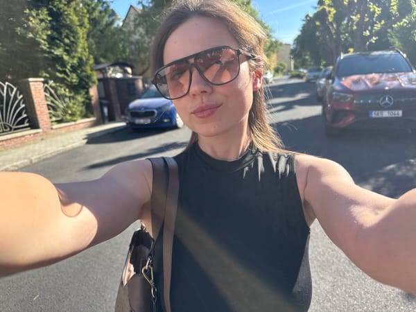 Woman takes selfies on sunny Karlovy Vary street