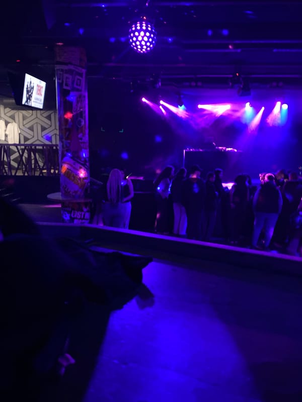 Indoor live performance draws crowd under colorful stage lights