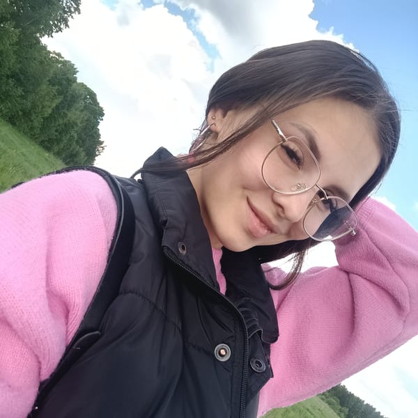 Woman takes selfies near roadside flowers and bus stop