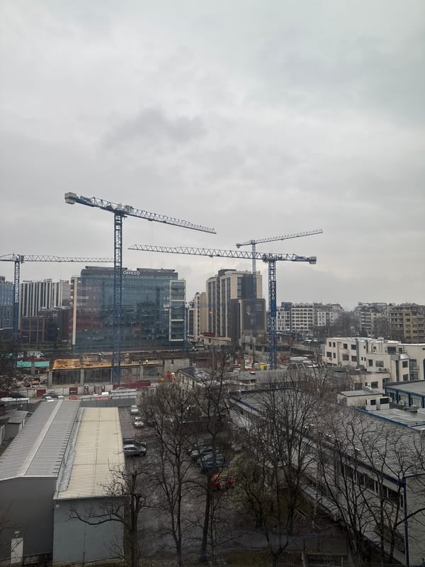 Construction cranes dominate Sofia skyline under overcast skies