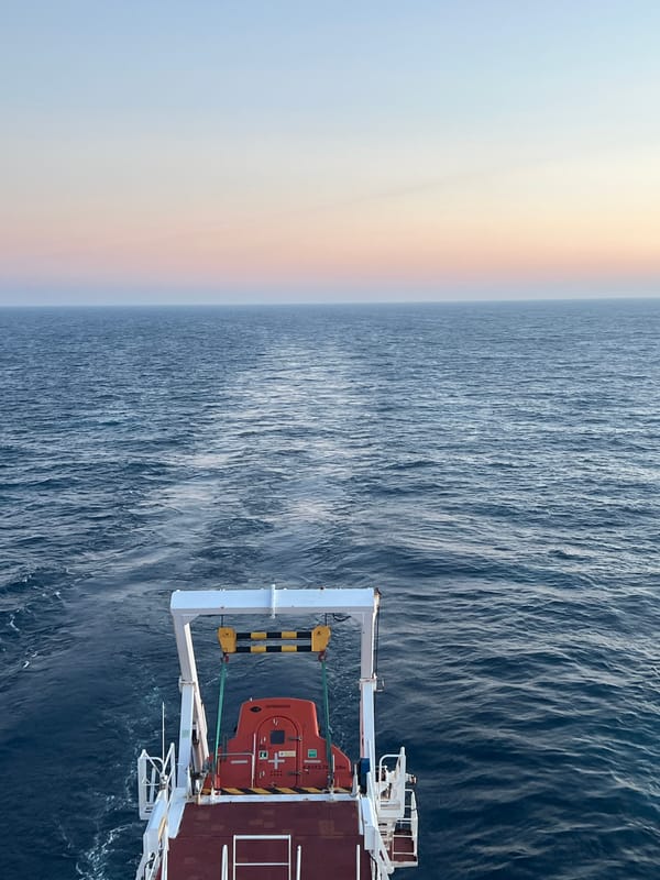 Ship at sea during golden hour, stern and aerial views
