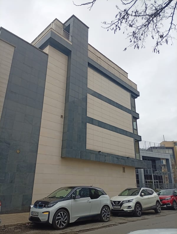 Modern building with parked cars observed in urban area