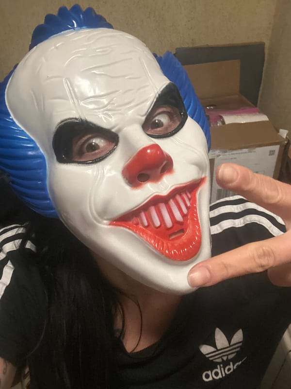 Person with clown mask, dog, selfie documented indoors