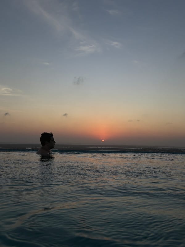 Man stands chest-deep in water during Tampico sunset