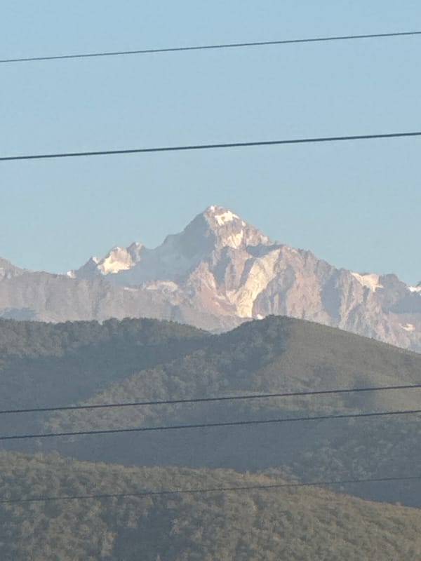 Snow-capped peaks rise above a Kazakh village on a clear day