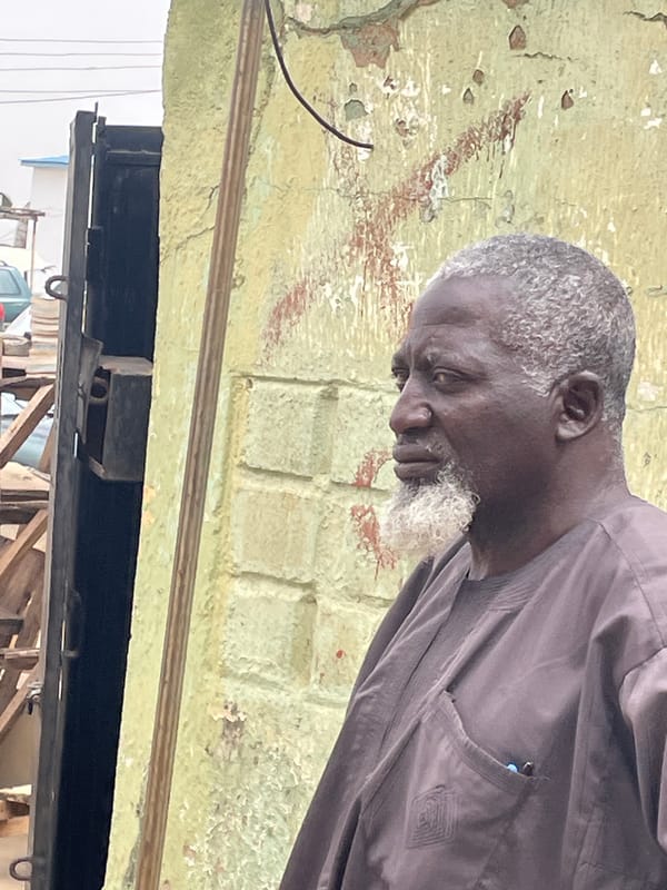 Everyday moments captured in Jos: elderly man, water tower