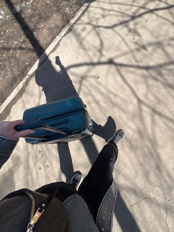 Traveler with suitcase navigates snowy Moscow sidewalk