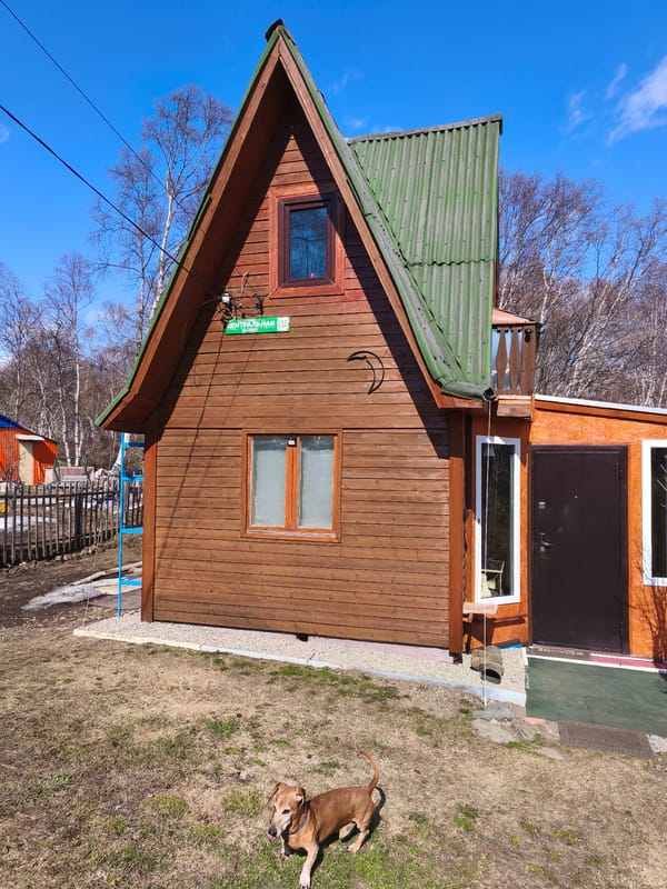 Brown wooden house with Cyrillic address sign documented