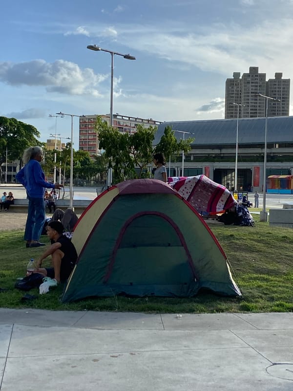 Outdoor gathering near muraled building in Caracas