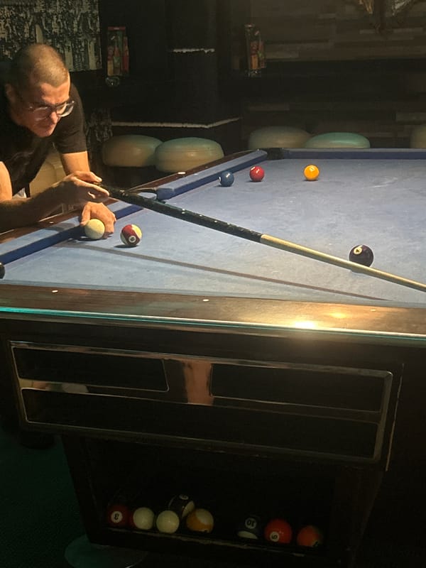 Man plays billiards on blue table in Pleven, Bulgaria