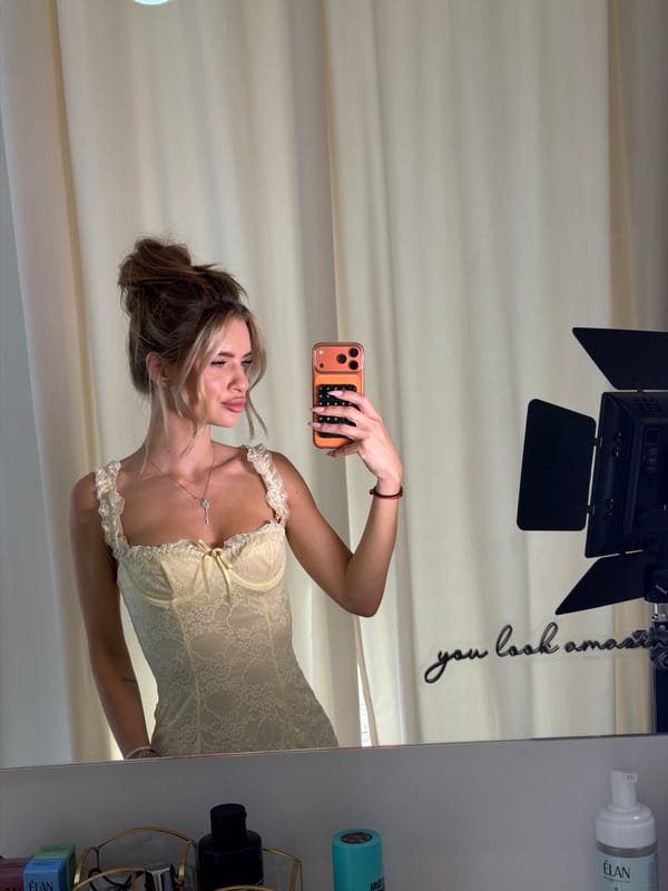 Mirror selfie in a sunlit Berlin room, yellow lace corset