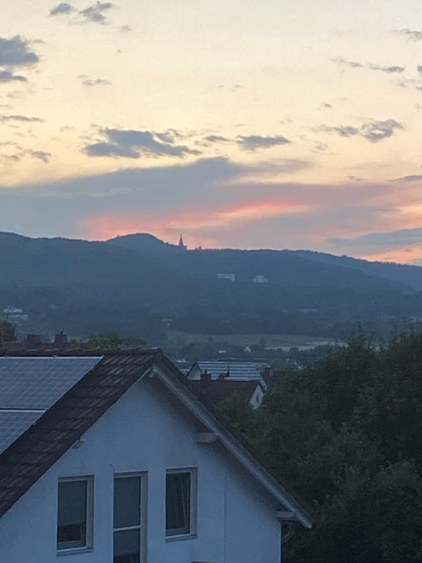 Kassel rooftop and hills at twilight, solar panels in view