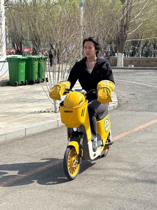 Worker rides electric tricycle on Zhongtun sidewalk