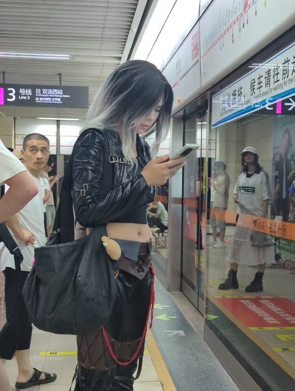 Waiting at a subway platform, scrolling through a phone