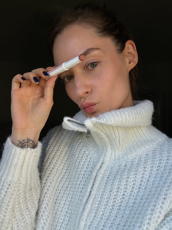 Woman applies lip balm in Kiel, Germany