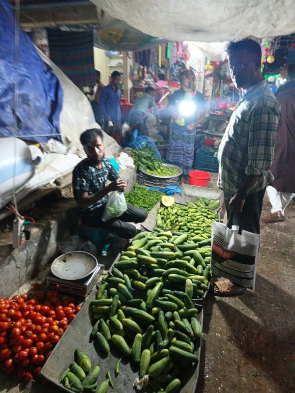Evening street market bustles with vendors in Kauria, Bangladesh