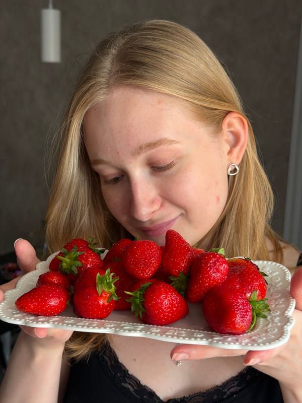 Woman holds plate of strawberries in Rossiyskiy, Russia