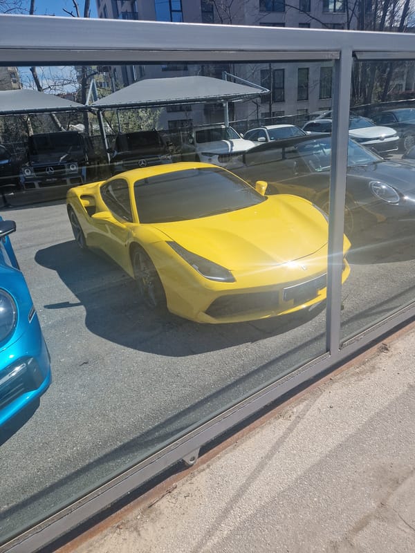 Yellow sports car spotted among parked vehicles on street