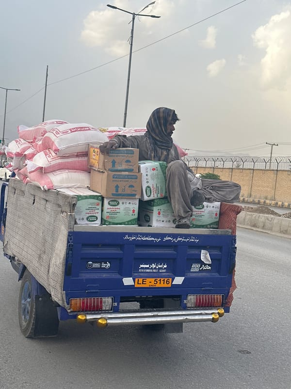 Man rides atop loaded vehicle in Quetta street