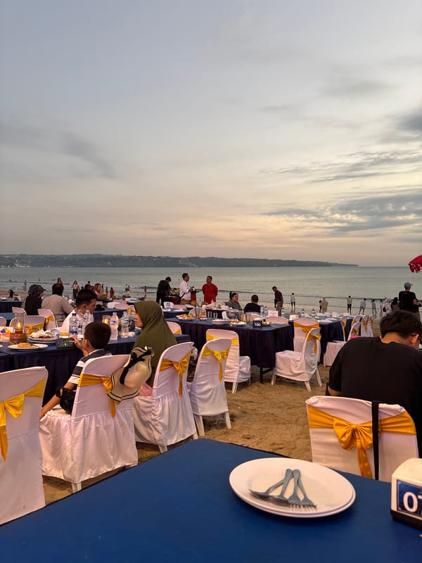 Elaborate beachfront dining setup at dusk in Kuta, Bali
