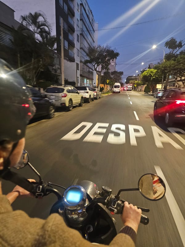 Motorcycle rider travels through Miraflores streets at night