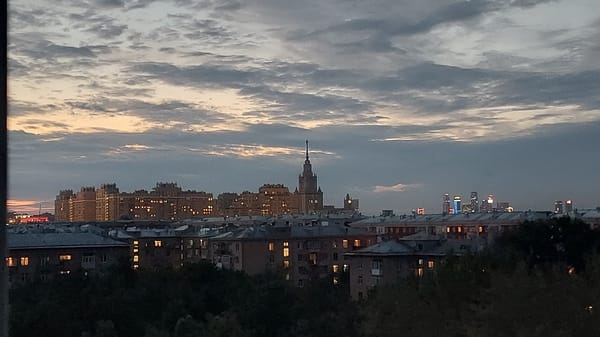 Stalinist skyscraper anchors a city skyline at dusk