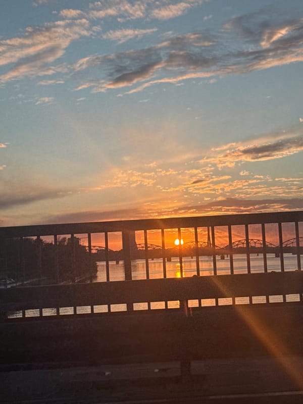 Gridded window frames a vivid sunset over Riga