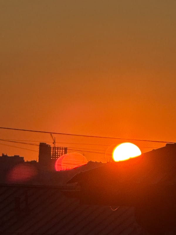Urban sunset glows warm orange at street level