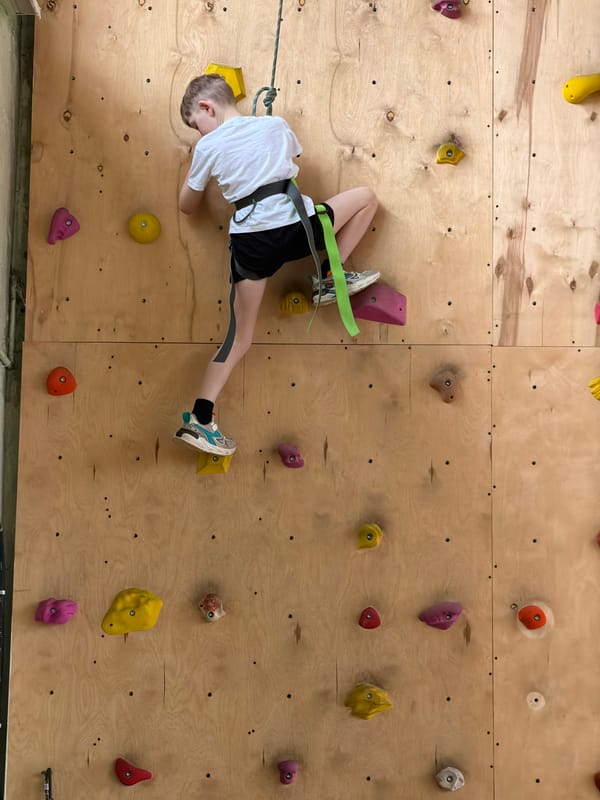 Boy rock climbs at indoor facility in Izhevsk, Russia