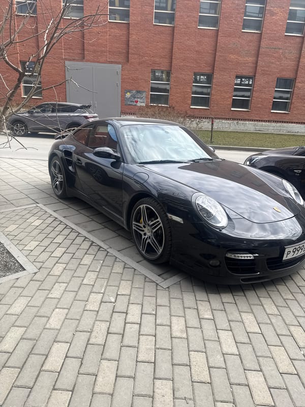Two cars parked on brick pavement in Yekaterinburg