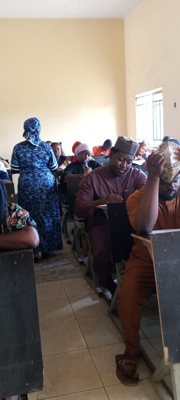 Adults take exam in Akwanga classroom