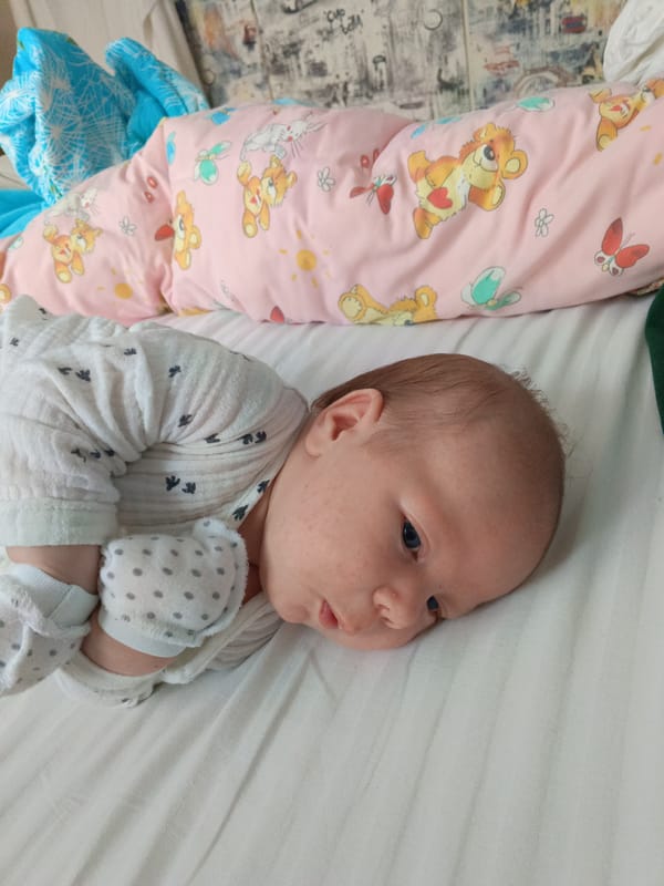 Baby observed resting on white bedding in Andreyevo, Russia