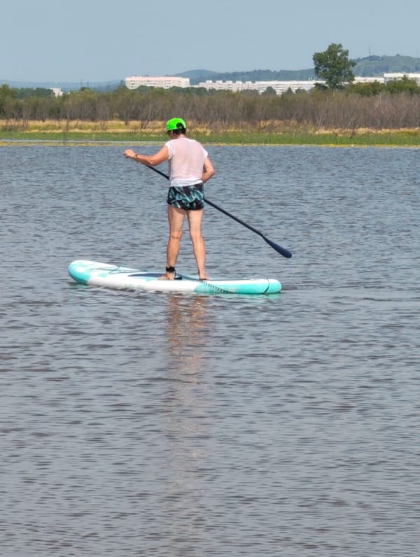 Paddleboarding on calm water, standing and kneeling