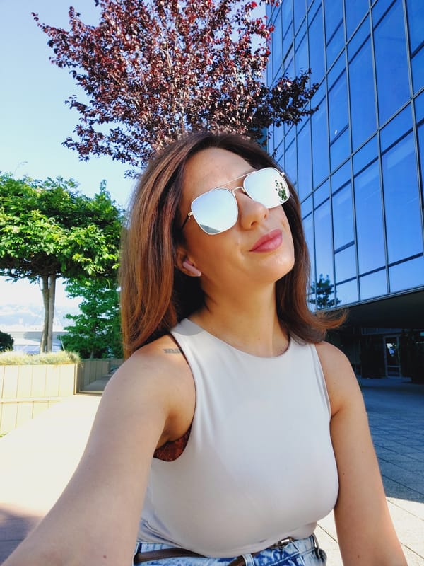 Back-to-back selfies outside a modern glass building