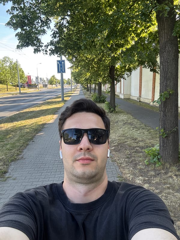Man takes selfie on tree-lined Pilsen sidewalk
