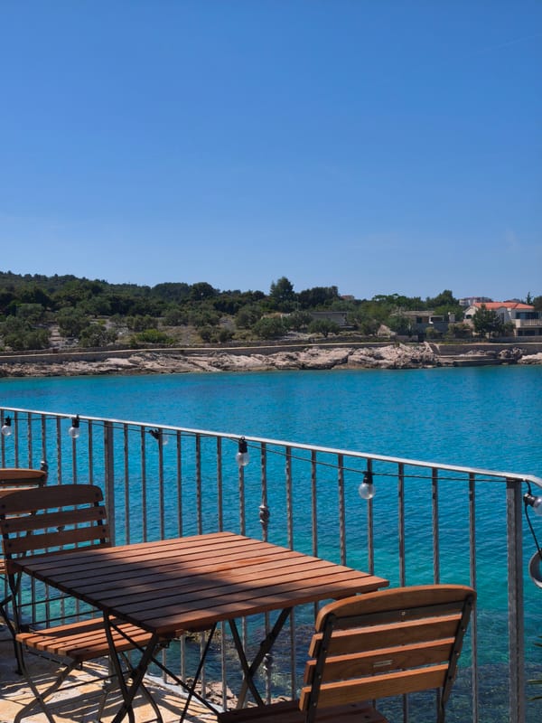 Coastal cove with turquoise waters and hillside dining captured