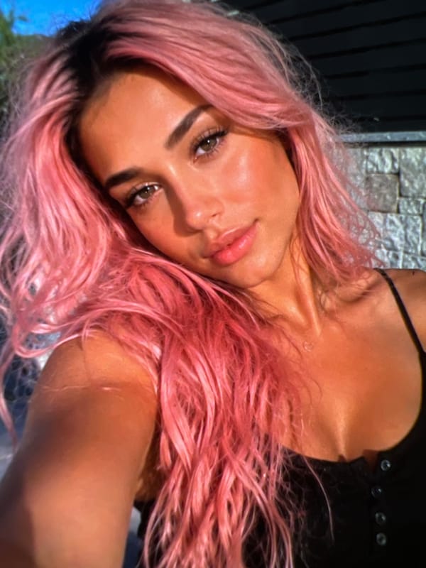 Pink hair, black fits, and a Guess bag selfie session