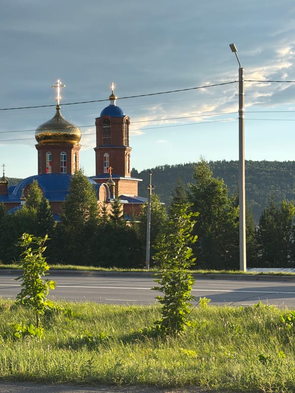 Rural roads and church domes under a golden sunset sky