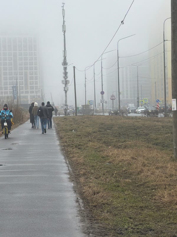 Pedestrians navigate foggy conditions on wet Murino sidewalk