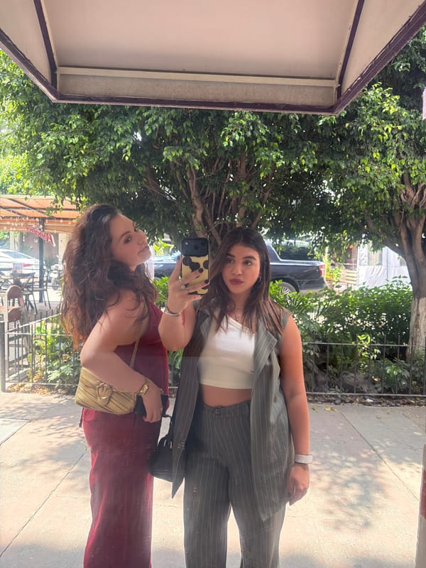 Women take selfies in storefront reflections in Mexico City