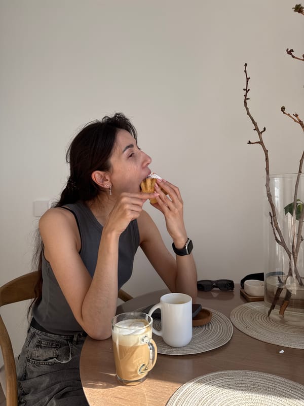 Woman enjoys cupcake at table in Perm, Russia