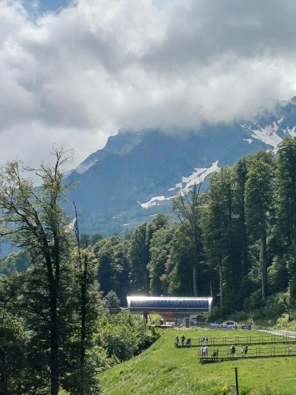 Summer day at Estosadok's ski lifts, Caucasus mountains in view
