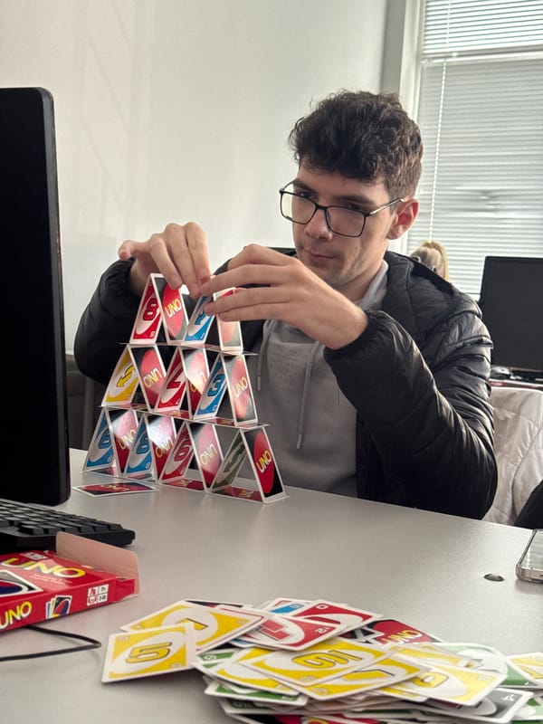 Man builds Uno card house in Bulgarian office setting