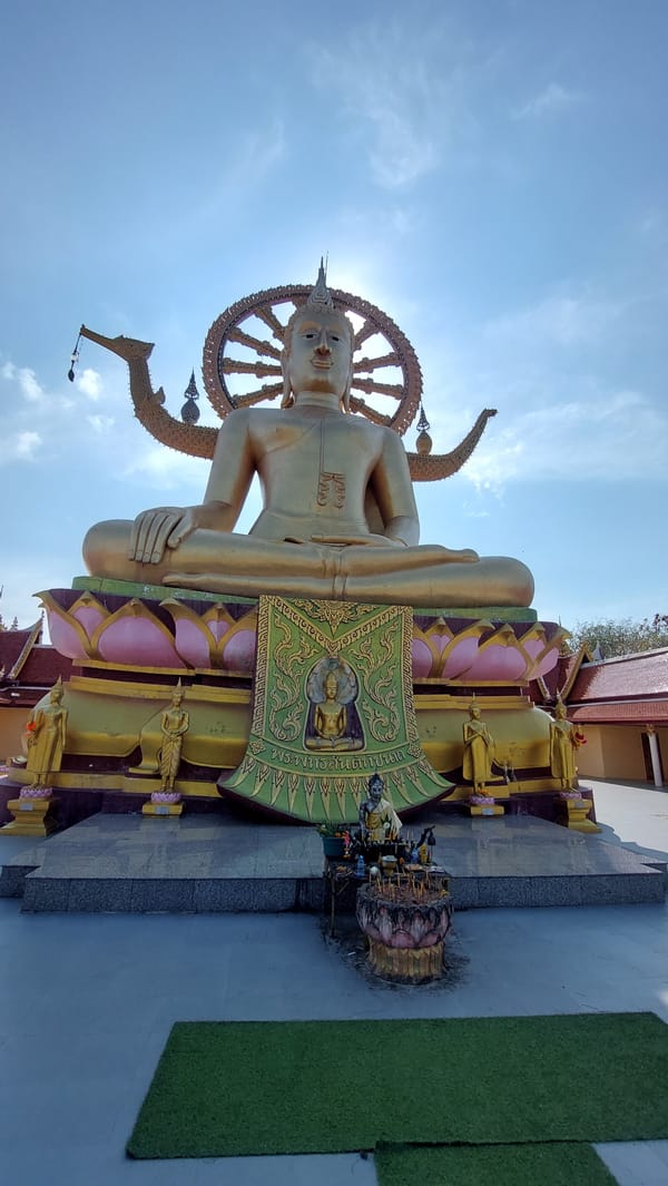 Temple visitor documents Buddhist statues at Baan Plai Laem