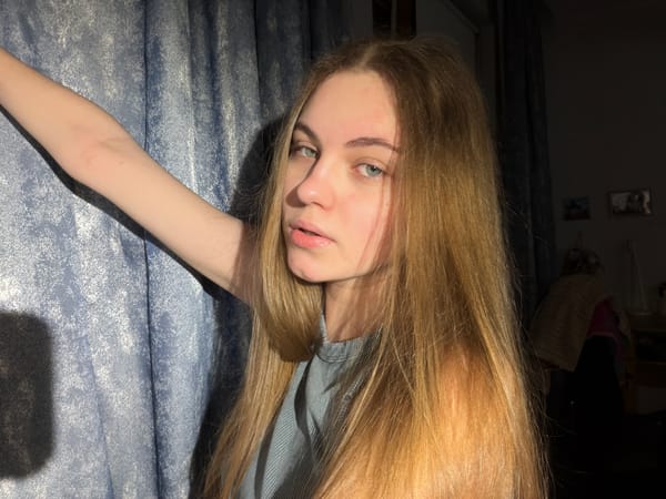 Indoor selfie session in a Dnipro bedroom, blue curtain backdrop