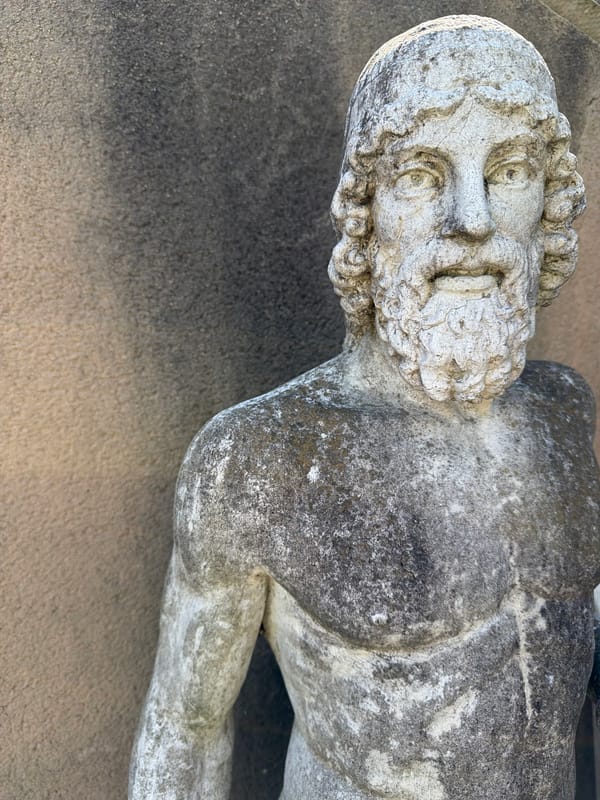 Weathered male statue lies sideways in French town