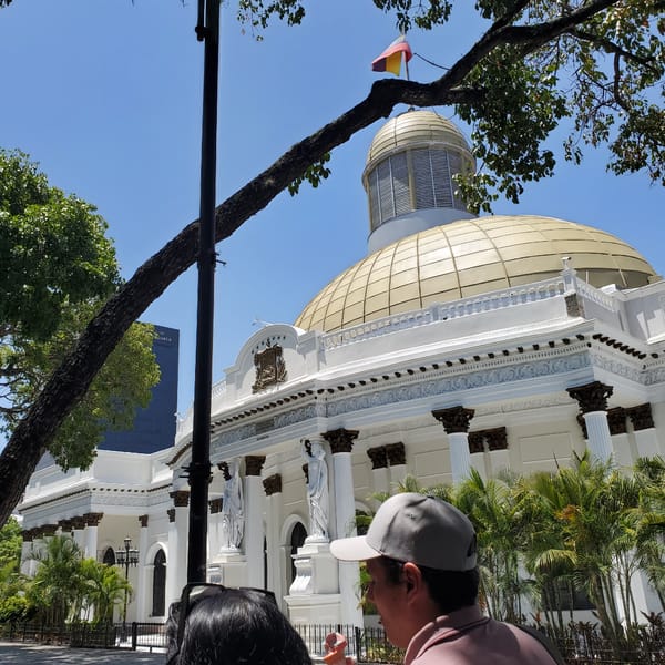 Tourist documents historic Caracas landmarks during afternoon walking tour