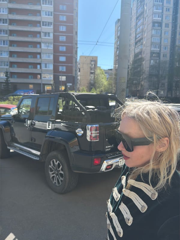 Woman poses with Jeep, meditation hashtag captured in Saint Petersburg